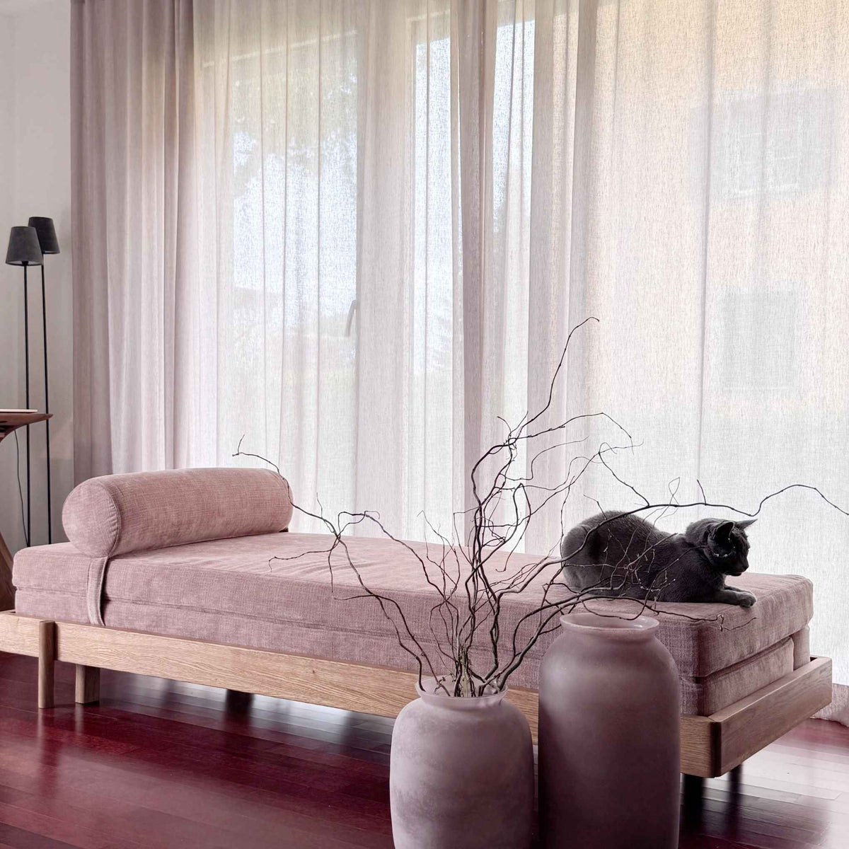 Cozy showroom scene: ÉLANDE Daybed in oak with Mare 10 fabric and the ÉTAUDORÉ cat lounging on top
